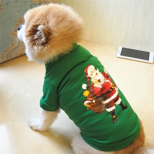 Detail view of a Pomeranian dog wearing a green Christmas Santa Claus printed pet T-shirt