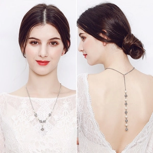 Detail of silver Y-shaped bridal necklace with pearls and crystal balls on a model