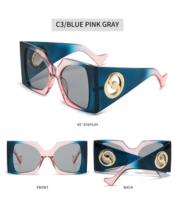 Detail of square oversized sunglasses with blue pink gray gradient and gold metal decor