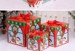 Three-piece nesting Christmas gift boxes in red and green with festive bows and characters