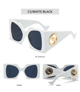Detail view of square sunglasses featuring white frames and gold swirl temple accents