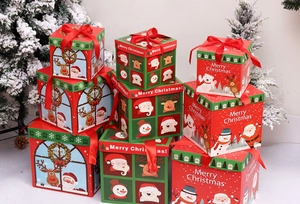 Close-up of stacked Christmas gift boxes in various sizes with festive ribbons on snow