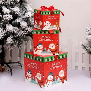 Stack of three red Christmas gift boxes with Santa patterns and festive snowflake decor