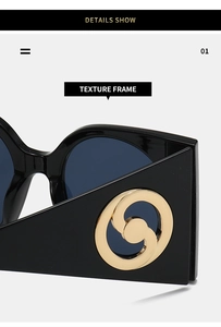 Close-up of black sunglasses with luxury golden spiral metal detail on the temple arm
