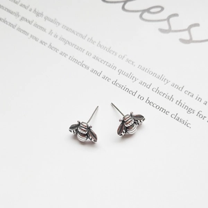 Macro shot of vintage 925 sterling silver bee stud earrings showing wing textures