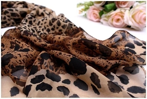 Detailed macro shot of soft chiffon leopard print scarf fabric with elegant roses