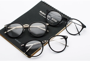 Close-up of retro round eyewear frames in black and gold with metallic temples