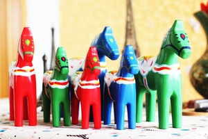 Detail of three colorful hand-painted wooden Dala horses with floral patterns