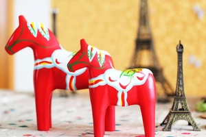 Close-up of a pair of red Swedish Dala horses with hand-painted floral Kurbits patterns