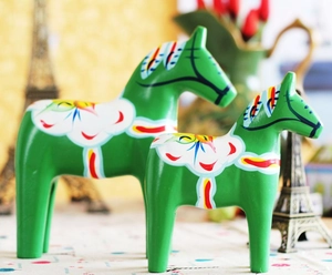 Detail of green Dala Horse statues with traditional Kurbits hand-painted floral patterns