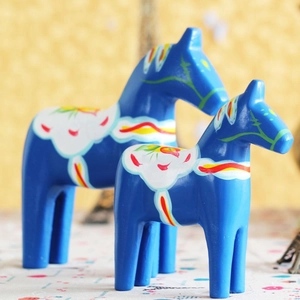 Close-up of two blue Dala horses with colorful traditional Swedish Kurbits floral patterns