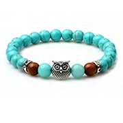 Detail of beaded yoga bracelet with turquoise stones and silver owl charm pendant