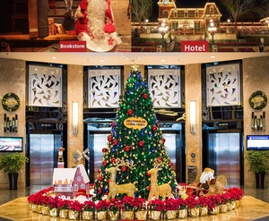 Lobby scene featuring a large frosted Christmas tree, reindeer decor, and poinsettia display