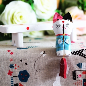 Detailed close-up of hand-painted wooden fishing cat figurine with a blue striped kimono