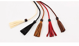 Detail of woven dress belts featuring wooden beads and tassels in five assorted colors
