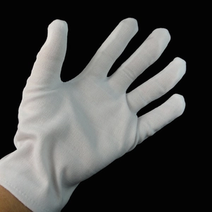 Classic white cotton gloves for Halloween costumes and magician performances on black background