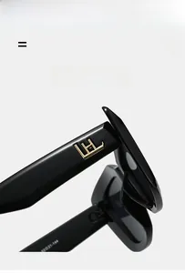 Gros plan de lunettes de soleil noires montrant le logo doré et les dimensions