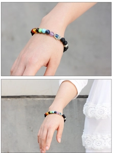 Detail of Hamsa Hand and Evil Eye charm on volcanic lava stone bracelet with colorful beads