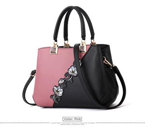 Detail of elegant patchwork handbag with floral embroidery and golden hardware