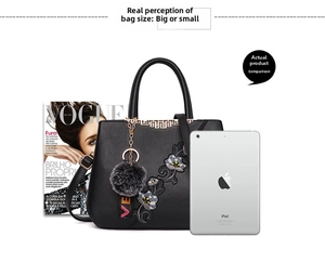 Detail of embroidered floral black handbag next to an iPad for size comparison