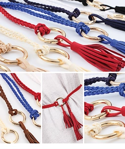 Detail of woven waist belts with metal O-ring buckles and tassels in various colors