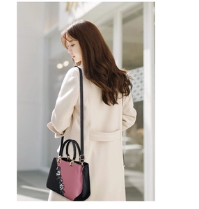 Detail of floral embroidery and sequins on black and pink contrast fashion handbag