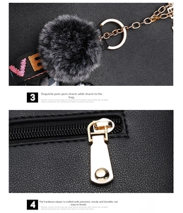 Detail of black pebbled leather texture with plush pom-pom and gold zipper hardware