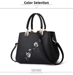 Close-up of black handbag with exquisite floral embroidery and golden hardware detail