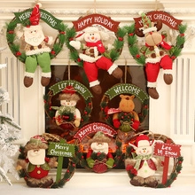 Close-up of assorted Christmas rattan wreaths with plush Santa, Snowman and Reindeer dolls