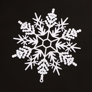 White hollow plastic snowflake ornament for Christmas tree decoration on black background