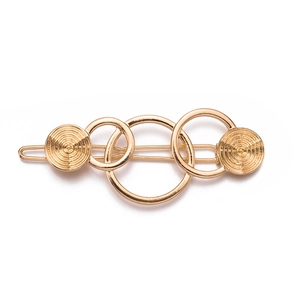 Gold geometric hair clip with interlocking rings and spiral textured discs on white background
