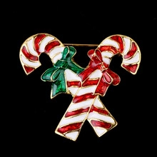 Close-up of golden candy cane brooch with red white and green enamel and bows