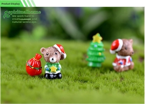 Makro-Detail von Miniatur-Weihnachtsbär und Baum aus Harz auf grünem Moos-Hintergrund