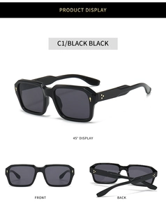 Detail of square sunglasses with golden metal arrow rivets on black frame and lenses