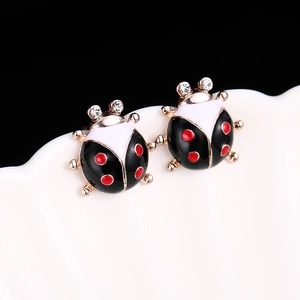 Vue macro de boucles d'oreilles coccinelle avec émail rouge et cristaux étincelants