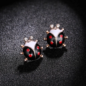 Vue macro des boucles d'oreilles coccinelle avec émail rouge et yeux en cristal