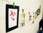 Detail showing colorful wooden clips and hemp rope holding Happy Anniversary photo cards