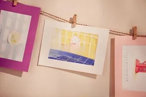 Dekorative Postkarten am Hanfseil mit Holzklemmen für kreative Wandfotodisplays