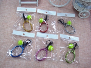 Detail view of colorful tennis racket keychains in multi-colored metal finishes