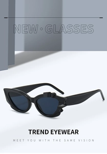Detail of black cat-eye sunglasses featuring geometric embossed frame and dark lenses