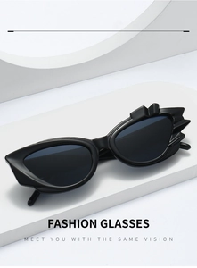 Detailed view of black cat-eye sunglasses with unique flame-shaped frame on a white stand