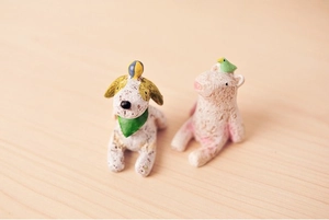Close-up of mini resin animal figurines including a dog and pig on a wooden surface