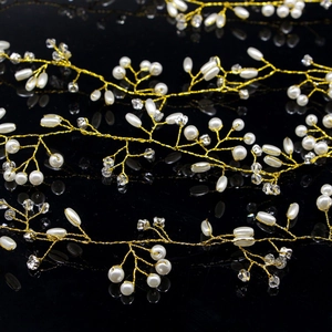 Detailed macro view of gold bridal hair vine with white pearls and clear crystals