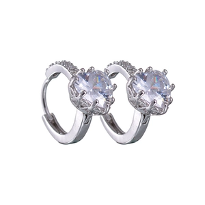 Detailed macro view of silver hoop earrings featuring crown-set cubic zirconia and hollow design