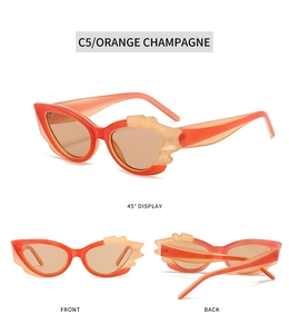 Detail view of orange champagne cat-eye sunglasses with unique flame-shaped frame