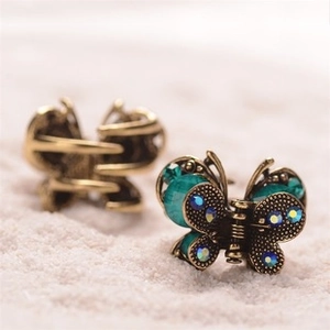 Macro detail of vintage bronze butterfly hair clips with blue crystal rhinestones