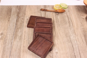 Detail view of square black walnut wood coasters featuring natural wood grain textures