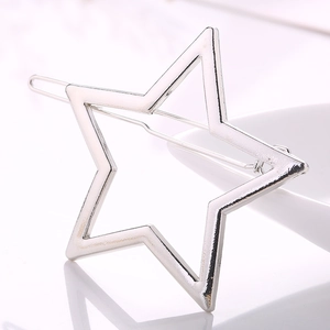Polished silver star hair clip detail with reflective metallic finish on white backdrop