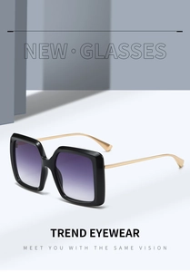 Détail de lunettes de soleil carrées avec verres dégradés violets et branches dorées