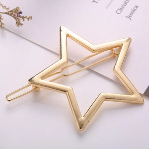 Elegant gold hollow star hair clip with a minimalist polished finish on a white surface